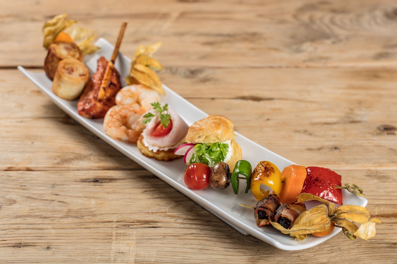 Fingerfood Catering serviert auf Porzellanplatte: Shrimps, Gemüsespieße